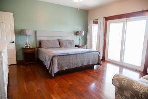 a bedroom with a bed and a wooden floor at The Gathering Premier stay for Large Groups in Millersburg