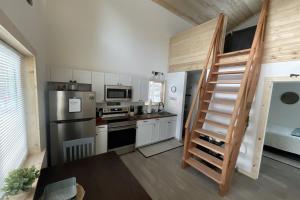 a kitchen with a staircase leading up to a loft at Seward Mountain View Cabins #7 in Seward