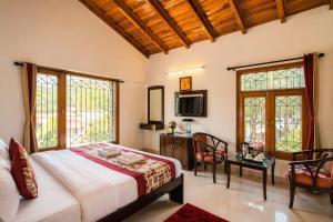 a bedroom with a bed and a table and chairs at The Regal IVY Hotel in Nainital