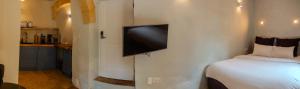 a bedroom with a bed and a flat screen tv on the wall at Talbot House by Talbot & Bons in Luqa