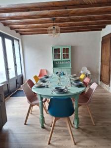 a dining room with a green table and chairs at Laroseliere in Mauléon