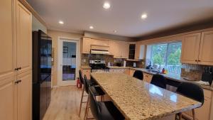 a kitchen with a large island with chairs around it at 7Bedroom Beautiful and spacious home in Surrey