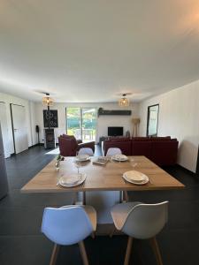 a dining table and chairs in a living room at L'échappée Belle Maison entre Pins et Océan in Bias