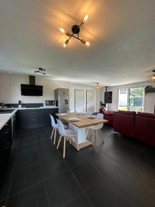 a kitchen and a dining room with a table and chairs at L'échappée Belle Maison entre Pins et Océan in Bias +20 photos