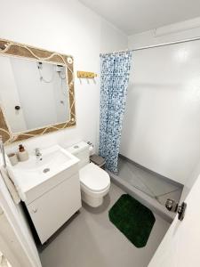 a white bathroom with a sink and a toilet at Surf & Sand Lobitos in Lobitos