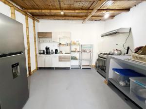 a large kitchen with white cabinets and a refrigerator at Surf & Sand Lobitos in Lobitos