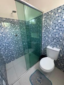 a bathroom with a toilet and a glass shower at Pousada Vilasboas in Parintins +34 photos