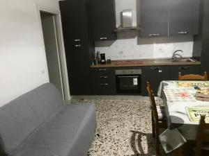 a kitchen with a couch and a table and a kitchen with black cabinets at House Catello 39 in Boscoreale +4 photos