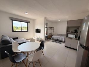 a kitchen and living room with a table and chairs at Studio Smart Ponte da Amizade in Foz do Iguaçu