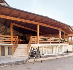 a building with a staircase and a wooden roof at Pensiunea Laura in Chişcău