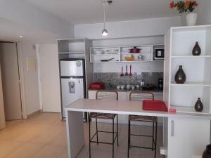 a kitchen with a white counter and a refrigerator at Quartier San telmo Piscina climatizada y Spa premium in Buenos Aires