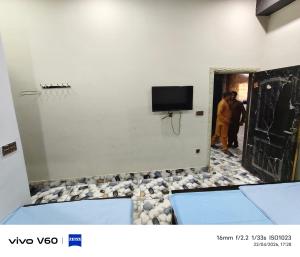 a room with a tv and a basketball hoop on the wall at Al Qadir Residence in Multan