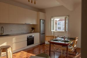 a kitchen and dining room with a table and chairs at Casa do Largo Ericeira in Ericeira