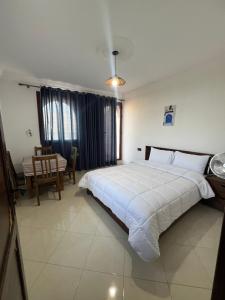 a bedroom with a large white bed and a table at Olea Azul in Chefchaouen +19 photos