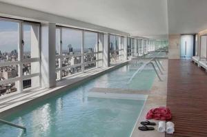 a swimming pool in a building with a view of the city at Quartier San telmo Piscina climatizada y Spa premium in Buenos Aires