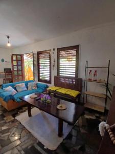 a living room with a blue couch and a table at Roses hostel e pousada in Pipa