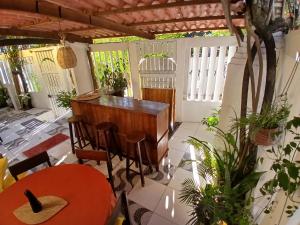 a patio with a table and chairs and a piano at Roses hostel e pousada in Pipa