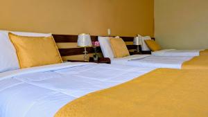 a hotel room with three beds and two lamps at Hotel San Lázaro Arequipa - Cochera - Hotel en Arequipa in Arequipa