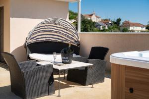 an outdoor table with chairs and a cup on a balcony at Adriatic Nest Residence in Tivat