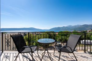 a patio with a table and chairs on a balcony at Adriatic Nest Residence in Tivat