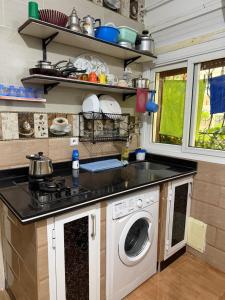 a kitchen with a stove and a washing machine at Apartamento con wifi in Nador