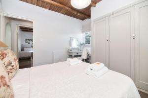 a bedroom with a bed with two towels on it at Walk Waterfront CliffPath Fireplace Secure-Parking in Hermanus