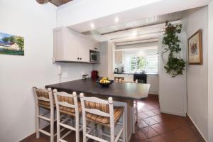 a kitchen and dining room with a table and chairs at Walk Waterfront CliffPath Fireplace Secure-Parking in Hermanus