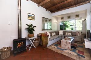 a living room with a couch and a fireplace at Walk Waterfront CliffPath Fireplace Secure-Parking in Hermanus