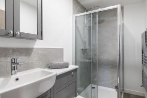 a white bathroom with a sink and a shower at Sussex House 20 - Artistic Luxe 1 Bed Apartment in Horsham +11 photos