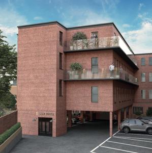 a brick building with a car parked in a parking lot at Sussex House 20 - Artistic Luxe 1 Bed Apartment in Horsham
