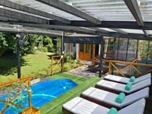 a patio with lounge chairs and a swimming pool at Casa Golf in Sierra de los Padres