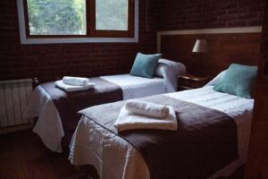 a hotel room with two beds with towels on them at Casa Golf in Sierra de los Padres +114 photos