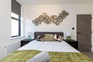 a bedroom with a bed with logs on the wall at Sussex House 20 - Artistic Luxe 1 Bed Apartment in Horsham