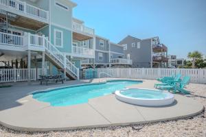 a pool in front of a building with a house at Wait N Sea by Oak Island Accommodations in Oak Island