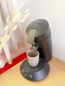 a coffee maker with a cup on a table at Atelier Marguerite, plain-pied au cœur de Tonnerre in Tonnerre