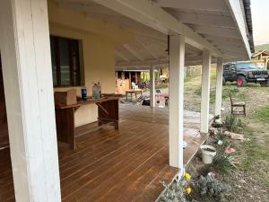 a porch of a house with a wooden deck at Horse Garden in Valea Groşilor