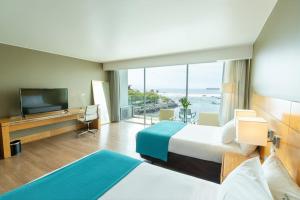 a hotel room with a large bed and a television at Terrado Suites Antofagasta in Antofagasta