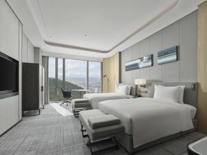 a hotel room with two beds and a television at Hilton Zhuji in Zhuji