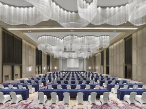 a large conference room with blue tables and white chairs at Hilton Zhuji in Zhuji +120 photos