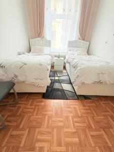 a bedroom with two beds and a wooden floor at Beenie 17 in Linz