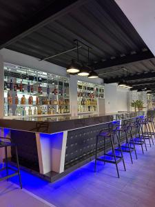 a bar with stools and bottles of alcohol at Hotel Capelli Talca in Talca