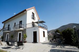 a white building with chairs in front of it at Villa Rossa in Agerola