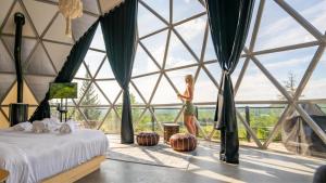 a woman walking in a room with a large window at Bel Air Tremblant Hotel - Dômes & Chalets in Mont-Tremblant