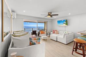 a living room with white furniture and a view of the ocean at Lahaina Roads 302 in Lahaina