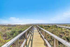 a wooden boardwalk leading to the beach at Jonahs Whale by Oak Island Accommodations in Caswell Beach