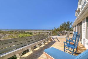 two chairs and a bench on a deck with the beach at Jonahs Whale by Oak Island Accommodations in Caswell Beach