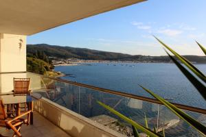 een balkon met uitzicht op een waterlichaam bij Departamento Esmeralda Pingueral in Dichato