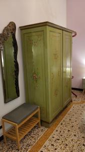 a green cabinet and a bench next to a wall at Contessa Alba in Savona