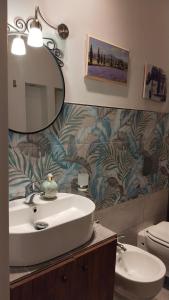 a bathroom with a sink and a mirror and a toilet at Contessa Alba in Savona