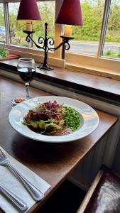 a plate of food on a table with a glass of wine at Jack & Jill Inn Pub in Hassocks +15 photos